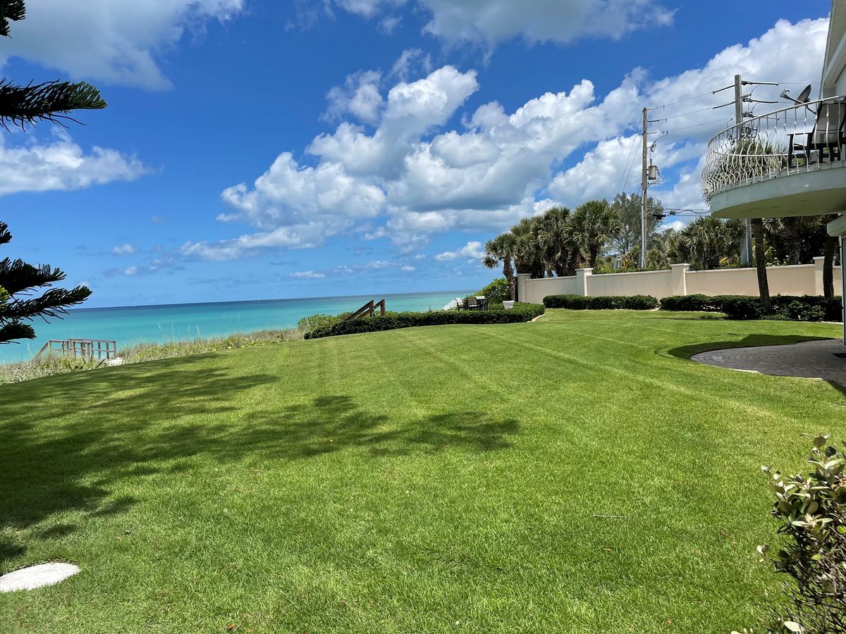 Waterfront lawn mowed clean to the seawall with the Gulf of Mexico beyond