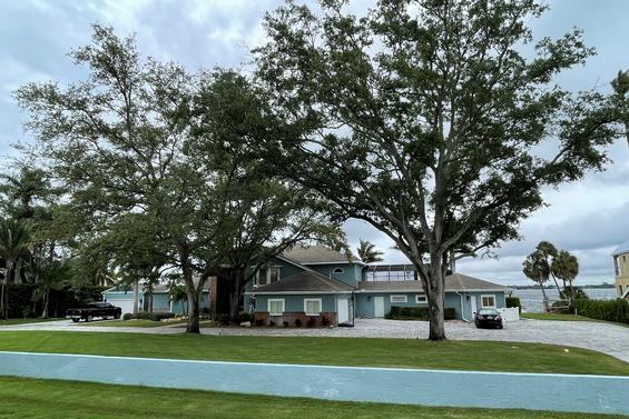 Waterfront property with a broad shade tree and mowed lawn running to the seawall
